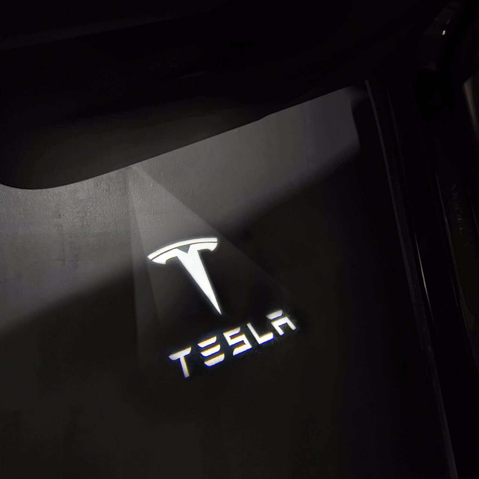 Tesla Model 3 / 3 Highland & Y / Y Juniper OEM Welcome Projection Lights illuminating Tesla logo on ground