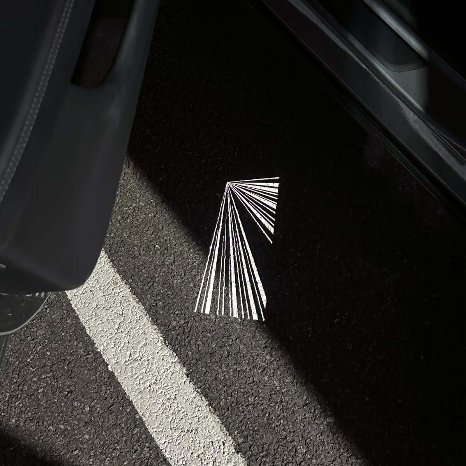 Tesla Model 3 / 3 Highland & Y / Y Juniper OEM Welcome Projection Lights logo projection on ground at vehicle entrance.
