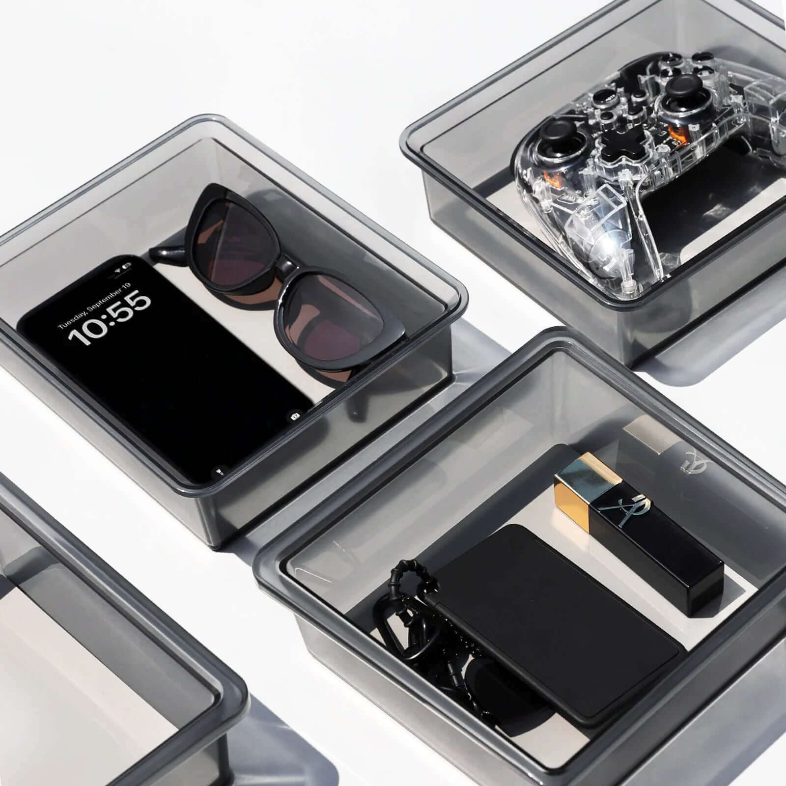 Close-up of clear storage drawers in Tesla Model 3 Highland 2024 organizer showing various items including a phone and sunglasses