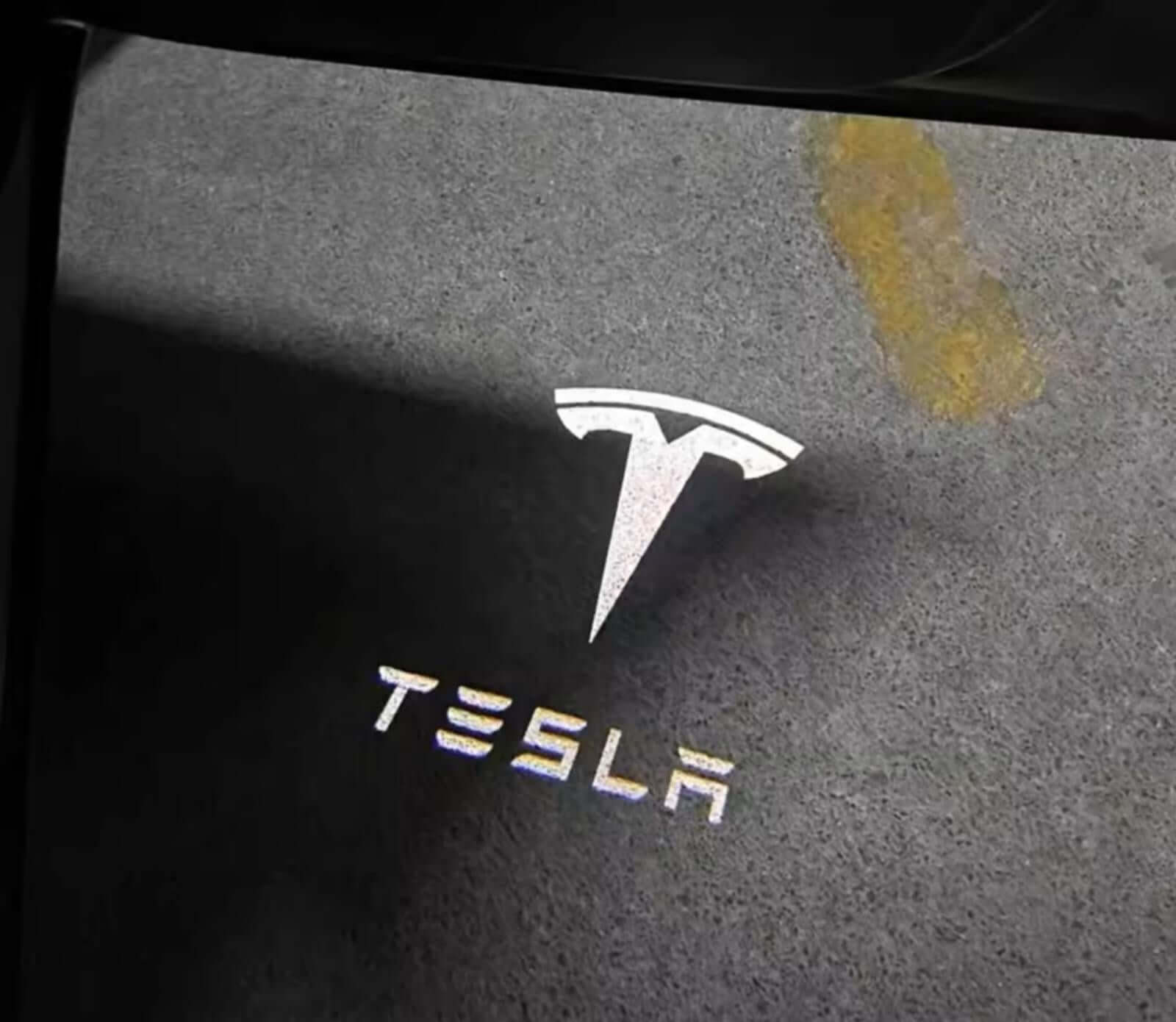 Tesla Model 3 / 3 Highland & Y / Y Juniper OEM Welcome Projection Lights displaying crisp projection of Tesla logo on ground